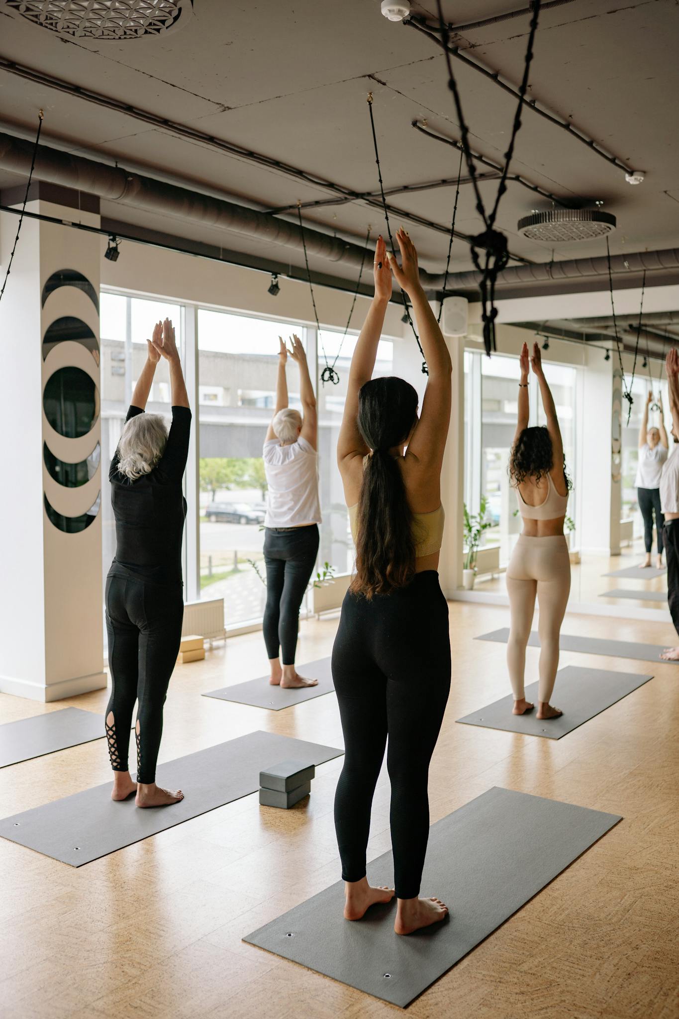 People practicing yoga in an indoor studio, focusing on relaxation and health.